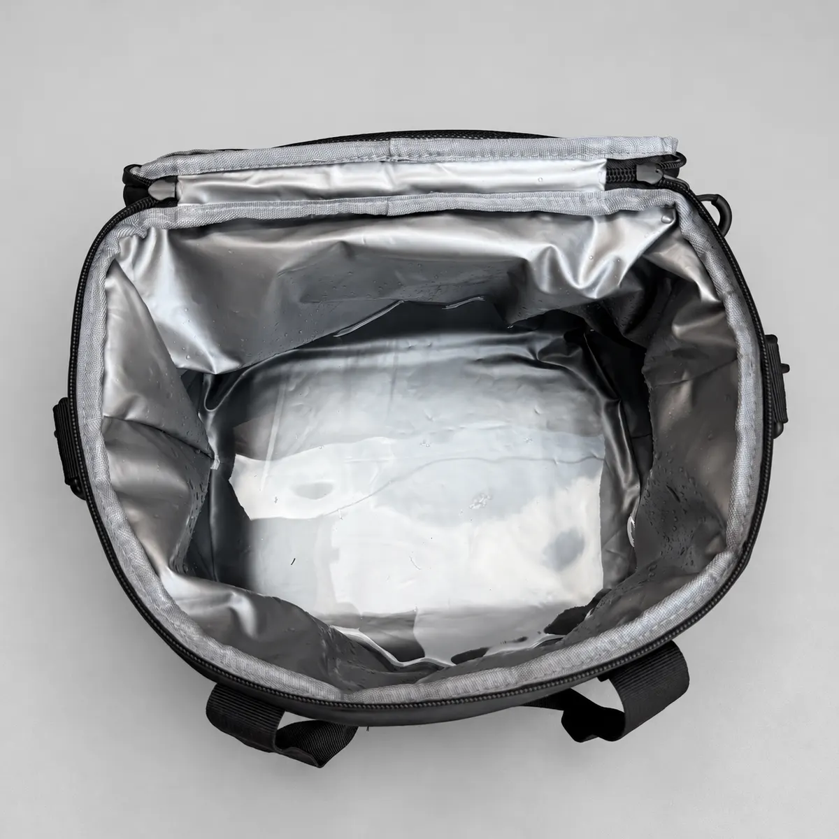 Open silver-colored liner of the soft cooler during the short standing-water observation